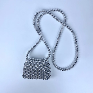 Detailed view of the handcrafted silver metallic beaded weave on a mini crossbody bag