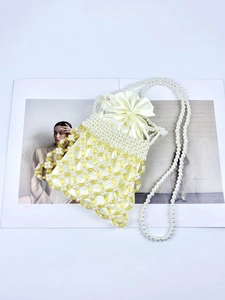Detail of handmade beaded bucket bag featuring pearl mesh and yellow satin drawstring liner