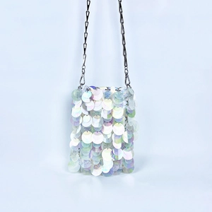 Close-up of iridescent white sequins on mini shoulder bag with silver chain strap