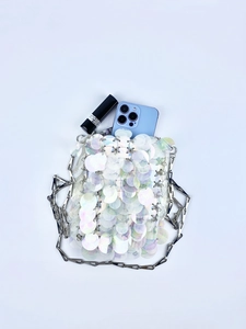 Macro detail of sequin crossbody bag interior showing phone and lipstick capacity