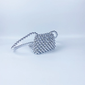 Macro detail of handcrafted silver beaded crossbody bag with woven pearl-like texture