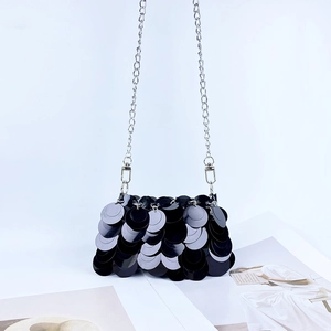 Détail du sac de soirée à paillettes noires avec chaîne argentée et effet d'écailles