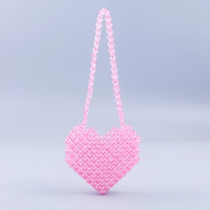 Detail of pink handmade beaded heart-shaped mini bag with transparent acrylic texture
