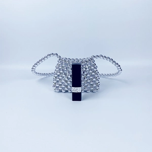 Macro detail of silver beaded mini bag with lipstick as a size reference guide