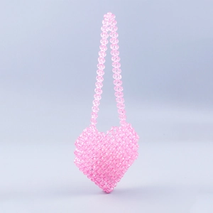 Detailed view of the pink heart-shaped beaded handbag with intricate woven patterns