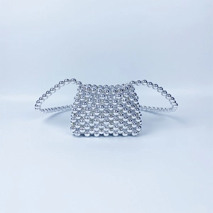 Detailed view of handmade silver beaded mini bag with reflective metallic finish texture