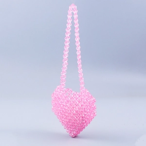 Close-up of pink heart-shaped mini beaded bag with handmade acrylic crystal texture