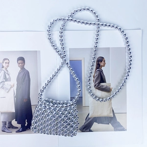 Detail of silver handcrafted beaded mini crossbody bag with polished metallic pearls