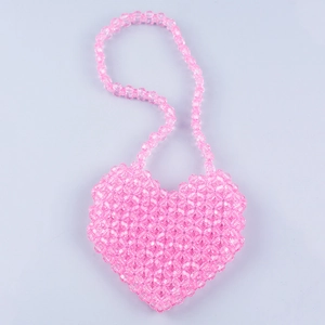 Close-up of handmade pink heart-shaped beaded crossbody bag with faceted acrylic beads