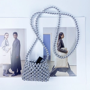 Close-up of handmade silver beaded mini crossbody bag with a round bead shoulder strap