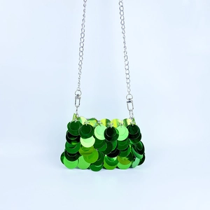 Détail d'un mini sac à paillettes vert émeraude avec une fine bandoulière argentée