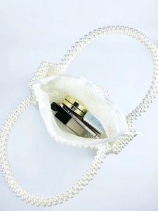 White pearl woven basket bag with silk lining showing interior capacity at 45 degree angle