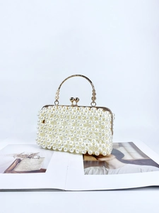 Detail of beaded pearl evening handbag with golden hardware and textured handle