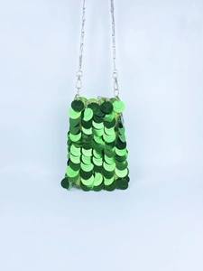 Detail of green sequin mini bag with metallic disc texture and silver chain strap