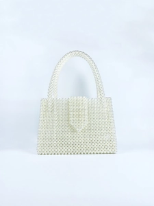 Detailed view of white pearl woven mini tote bag featuring handmade beaded texture
