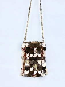 Detailed view of golden sequin mini bag with metallic discs and fine chain strap
