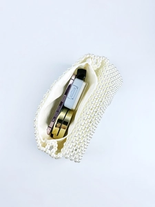 Interior view of white pearl beaded bag showing phone and cosmetics storage space