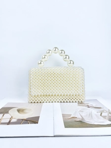 Handmade cream pearl beaded handbag with large round pearl handle on fashion magazine