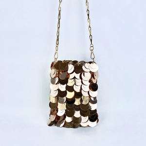 Detail of shimmering gold oversized sequins on a mini chain crossbody bag for evening wear