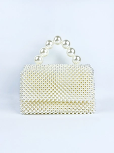 Elegant handmade pearl beaded handbag with large round handle on blue background