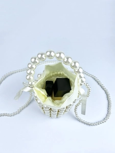 Macro view of handmade pearl bucket bag showing satin lining and drawstring interior storage