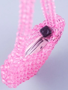 Pink acrylic beaded mini crossbody bag showing storage capacity for phone and lipstick