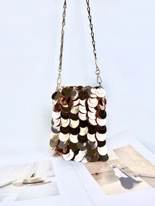 Detail of golden sequin mini bag featuring layered fish-scale texture and chain strap
