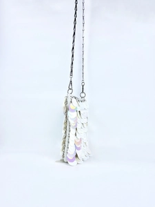 Detail of white iridescent sequin handbag with silver metal chain strap texture
