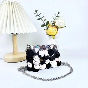 Détail de paillettes noires et argentées sur un sac de soirée élégant avec chaîne