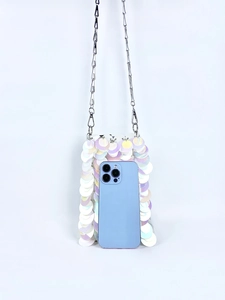 Macro shot of iridescent round sequins and silver metal chain strap on a mini crossbody bag