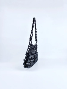 Détail d'un sac à bandoulière noir fait main en perles de résine brillantes avec texture