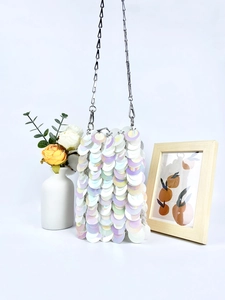 Detailed view of iridescent sequin mini crossbody bag with silver metal chain strap