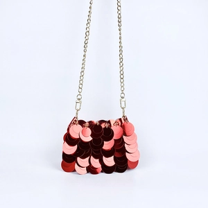 Détail du sac de soirée à paillettes rouges avec chaîne dorée et écailles réfléchissantes