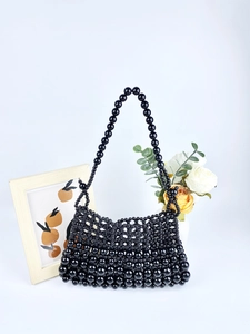 Détail d'un sac hobo noir fait main en perles brillantes avec une touche artistique
