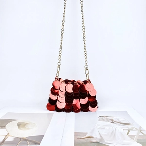 Détail de sac de soirée à paillettes rouges avec chaîne dorée et fermoir mousqueton