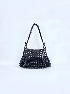 Détail du sac à bandoulière en perles noires fait main avec texture tissée brillante