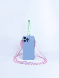 Vista macro della borsa a fragola con perline rosa, manico verde e confronto con telefono