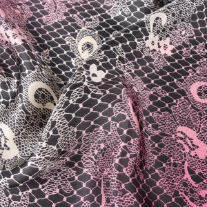 Dettaglio della sciarpa di seta con sfumatura rosa e stampa in pizzo nero