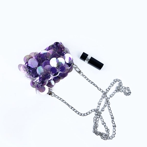 Détail du mini sac de soirée à paillettes mauves avec chaîne argentée et texture brillante