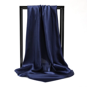 Detail of navy blue satin silk scarf showing smooth texture and elegant glossy drape