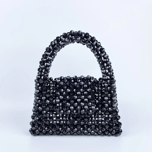 Detail of hand-woven black beaded handbag featuring faceted beads and vintage style