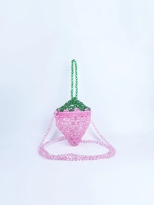 Dettaglio borsa di perline a forma di fragola con perle rosa e manico a foglia verde