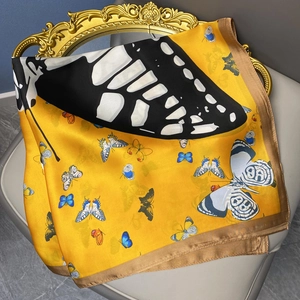 Pañuelo de seda amarillo con estampado de mariposas sobre marco dorado vintage