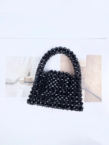 Detailed close-up of handmade black beaded handbag featuring faceted crystal beads