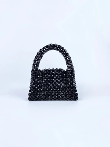 Detail of hand-woven black beaded handbag with faceted acrylic beads and arch handle