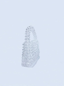 Close-up of handmade transparent beaded handbag showing intricate woven texture