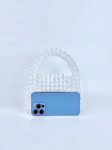 Close-up of handmade transparent beaded handbag with iPhone for size reference