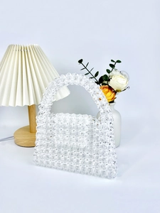 Detail of handmade beaded handbag with transparent acrylic beads and sturdy top handle