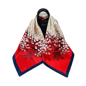Carré de soie de 90 cm avec imprimé arbre en rouge et beige sur un sac à main