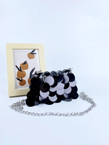 Pochette de soirée chic à paillettes noires avec bandoulière chaîne argentée sur fond bleu